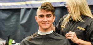 A midshipman getting a haircut in the barber shop