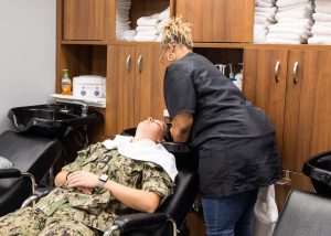 A midshipman having her shampooed in the beauty shop