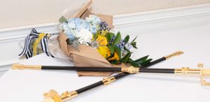 Midshipman swords sitting next to a bouquet of flowers