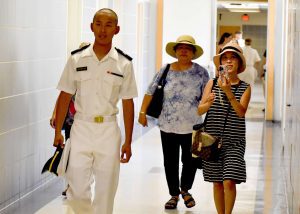 A midshipman and his family walking in a hallway