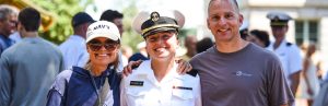 A father and mother posing for a photograph with their midshipman daughter