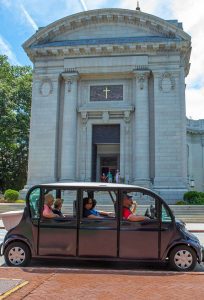A group of visitors touring the USNA in a car