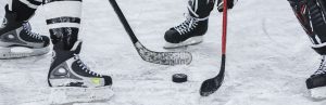 A closeup of hockey sticks and a puck