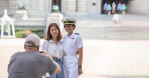 A midshipman posing with a family member for a photograph