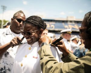 A young woman with her parents at commissioning